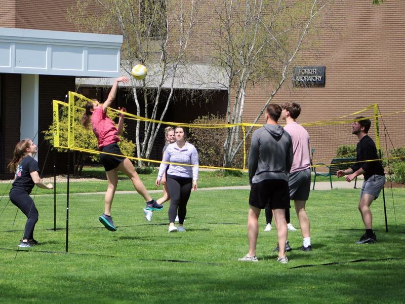 Group of student playing four square volleyball outside