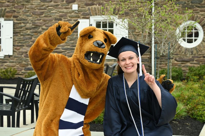 Nittany Lion mascot and female graduate outdoors
