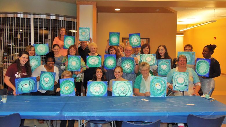 Participants of last year's Scoop & Paint event pose for a picture with their completed projects