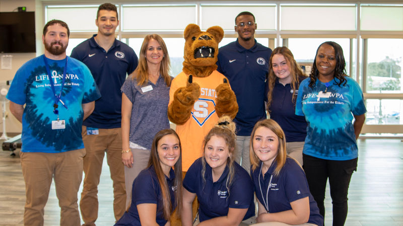 Several men and women pose with the Nittany Lion at LIFE-NWPA