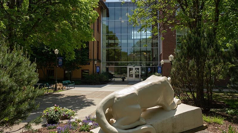 The Lion Shrine looks over the entrance of Lecture and Sharon halls on a bright summer day. 