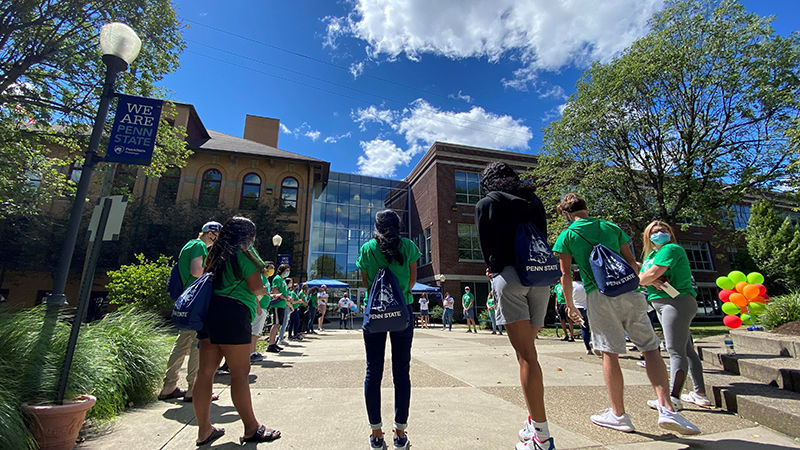 Students stand in a circle outside of the campus atrium