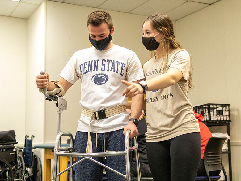 Two physical therapy students practicing with clinic tools