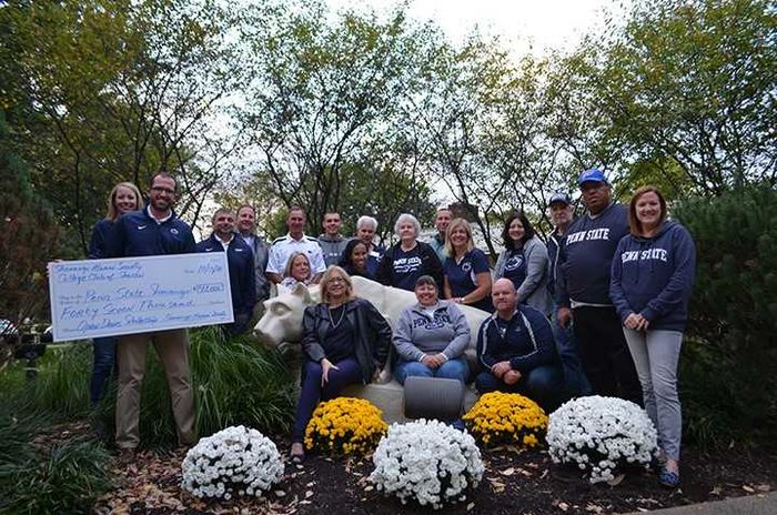A group of men and women in front of the Nittany Lion at Shenango campus.