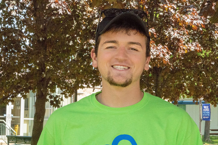 A young man wearing a hat and a green t-shirt.