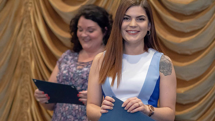 Business management and marketing student accepts award certificate