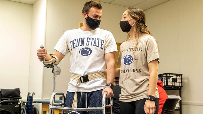 Two physical therapist students work with adaptive devices. 