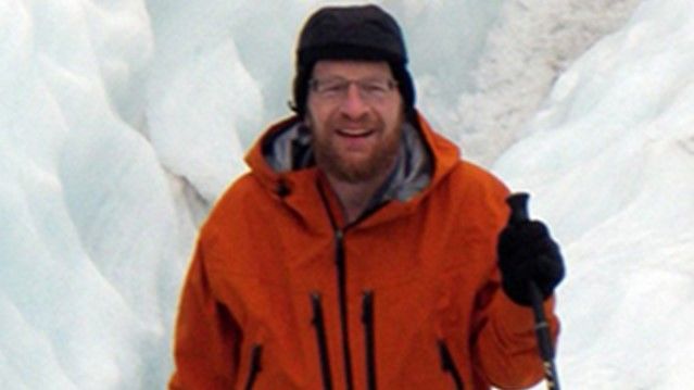 Picture of Dr. Richard Alley with ski poles and surrounded by ice.