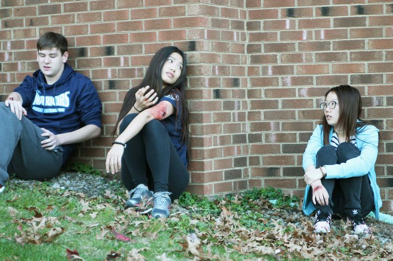 Three "wounded" students sit against the wall during an active shooter exercise at Penn State Beaver
