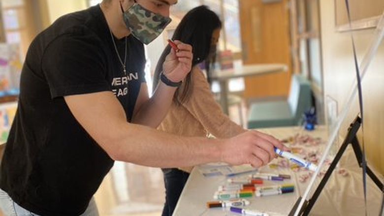 Two students writing on a poster