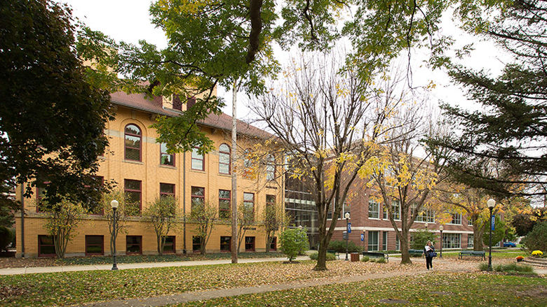 Lecture Hall and Sharon Hall are shown connected by an atrium in the fall, surrounded by colored leaves