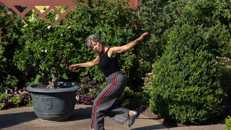 Woman tap dancing among trees