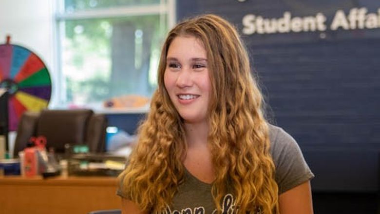 A young woman with wavy blond hair in the Student Affairs office at Penn State Shenango.