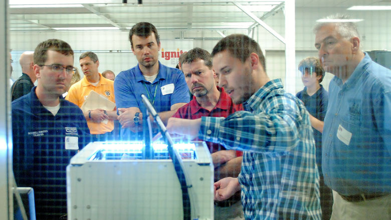 A person demonstrates a 3-D printer at the Innovation Commons