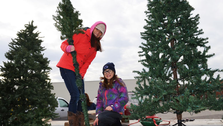 A woman and child build trees on top of the Penn State Shenango float