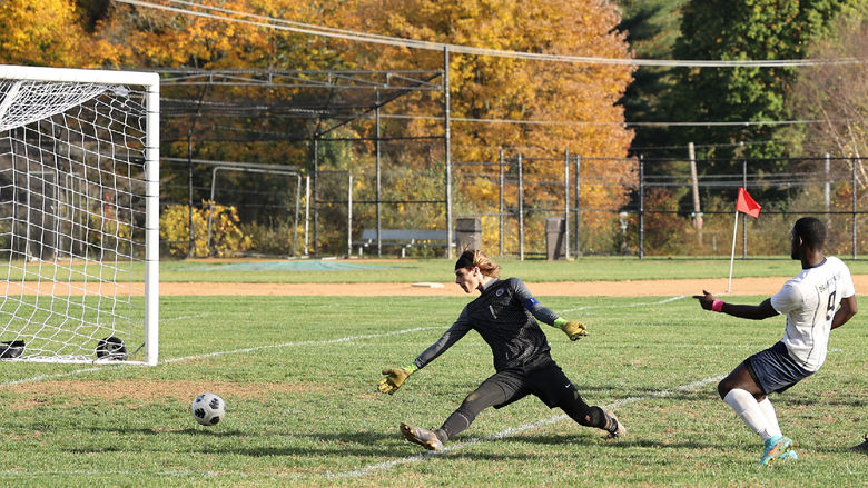 A Brandywine men's soccer player sends the ball past the opposing team's goalkeeper.