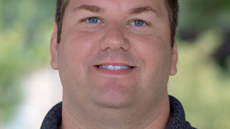 A headshot of a brunette male