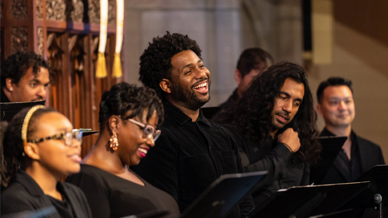 Several members of a choir singing joyously together