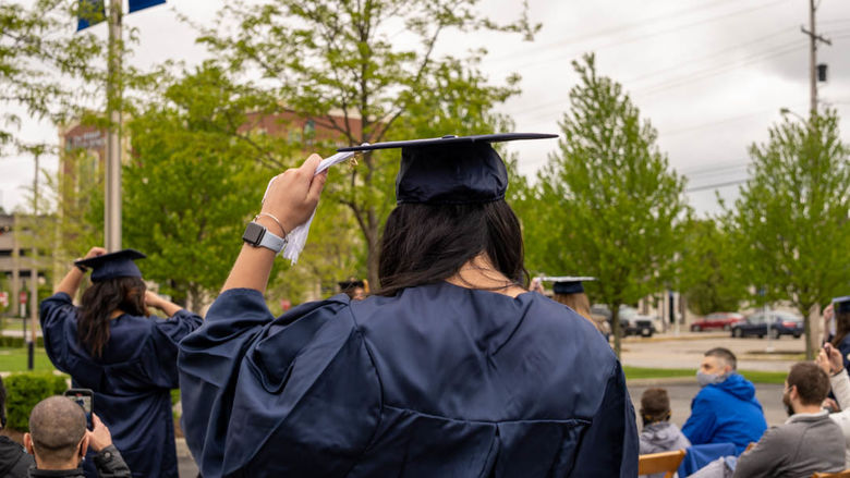Two graduates moving tassel to the left