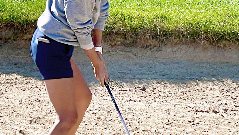 Gianna Effinite prepares her swing on a golf course.