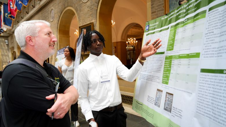 A student presents a scientific poster to a person