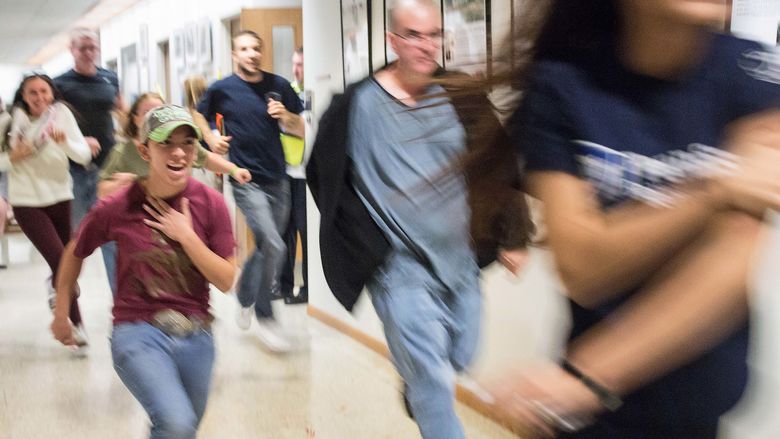 Students flee the building during an active shooter training drill at Penn State Beaver.