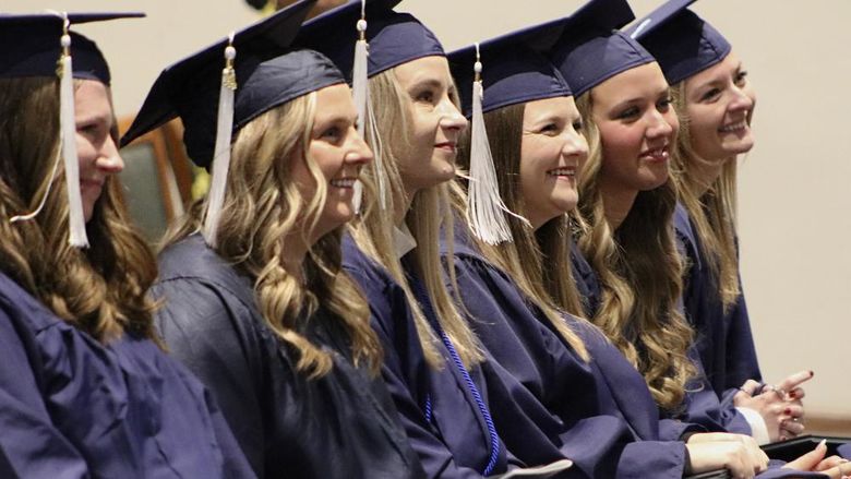 Graduates wearing caps and gowns smiling