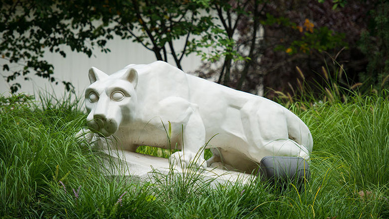 Lion statue surrounded by tall grasses