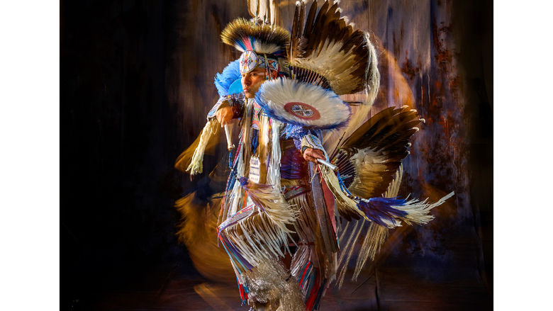 Supaman wearing beautiful traditional Native American clothing and dancing