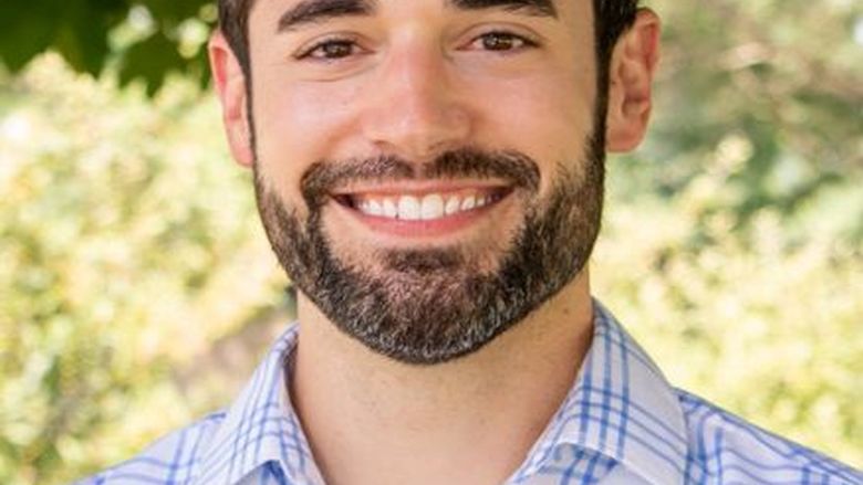 A brunette man with a beard.