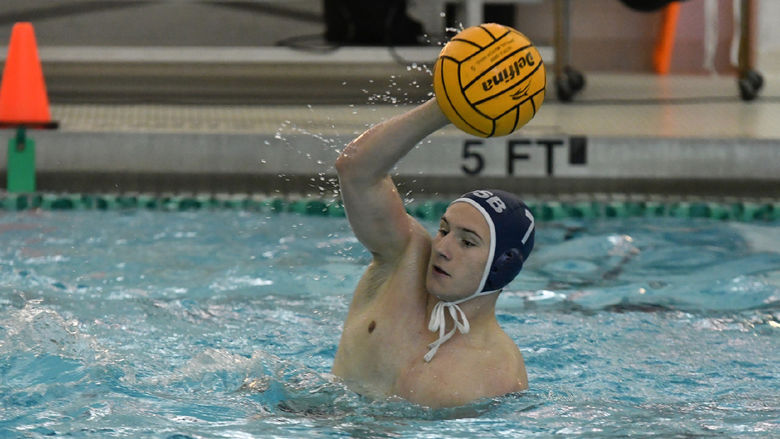 A Penn State Behrend men's water polo player catches the ball.