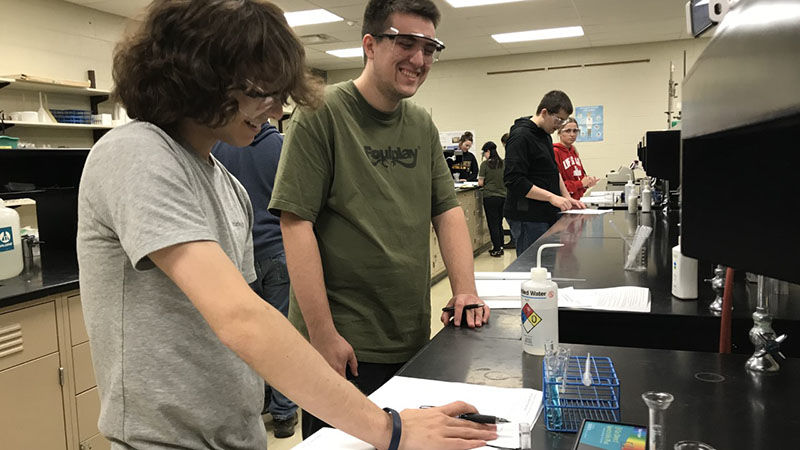 Two males students looking over equipment in chemistry lab at Shenango campus.