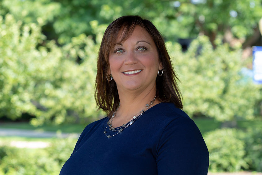 Picture of woman outside with trees in background