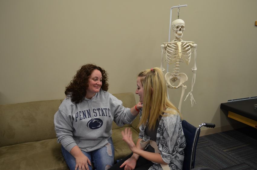 OTA student Sara Wasacz works on another student during a lab