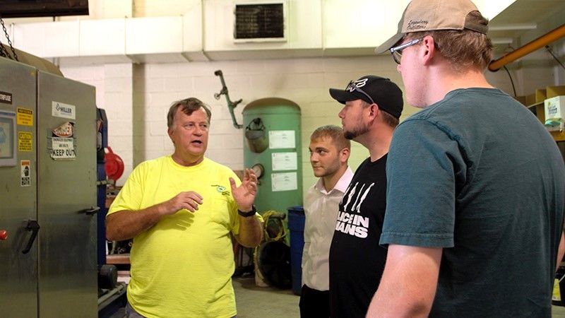 Four men standing together inside local sewer plant