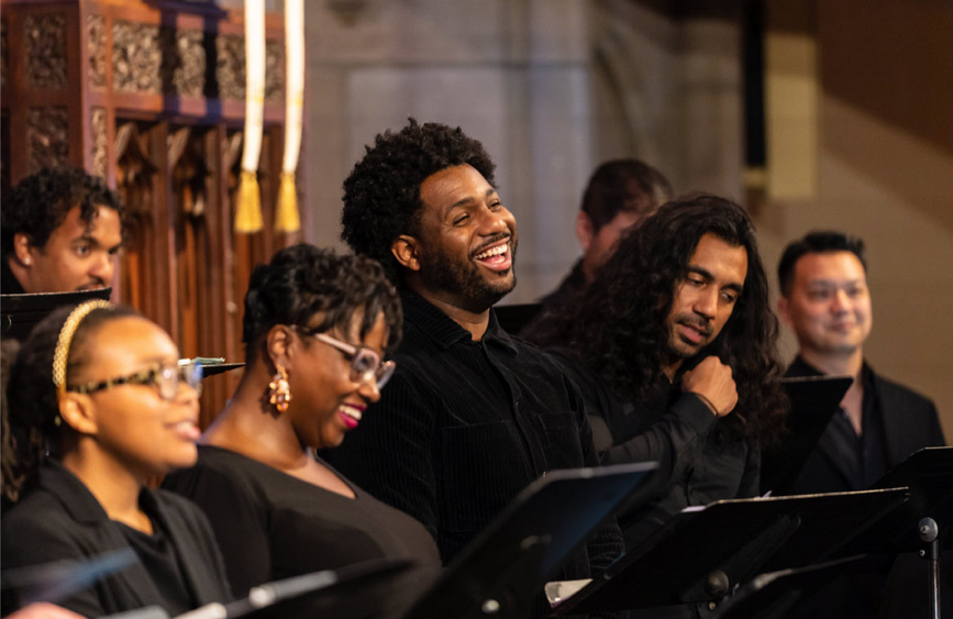 Several members of a choir singing joyously together