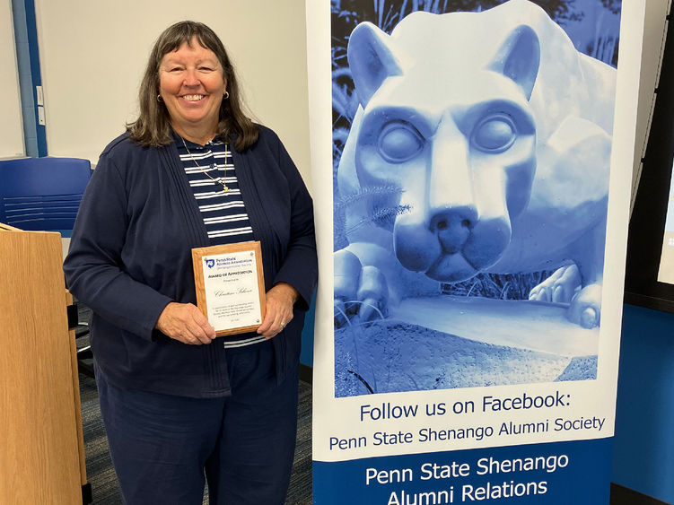 Christine Scherer poses with a plaque