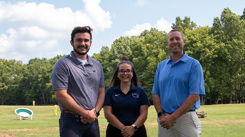 Ty Cole, Amanda Howett, and Tom Roskos in front of golf driving range