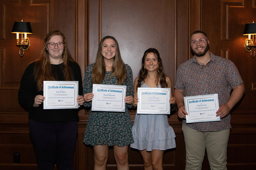 four students hold paper certificates