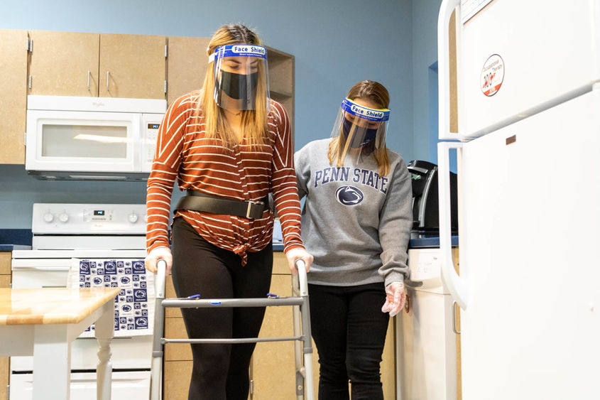 Two students use walker in kitchen