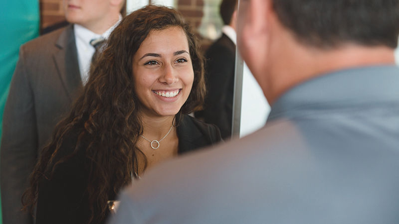 Woman at career fair talks with potential employer 