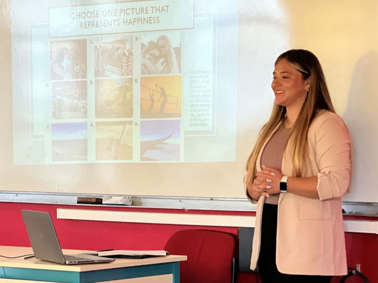 Jessica Divens standing by a white board giving a presentation