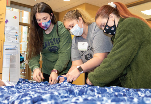 Students tying blankets