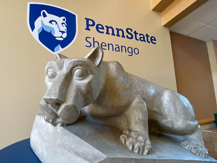 Lion Shrine posed in front of Penn State Shenango logo